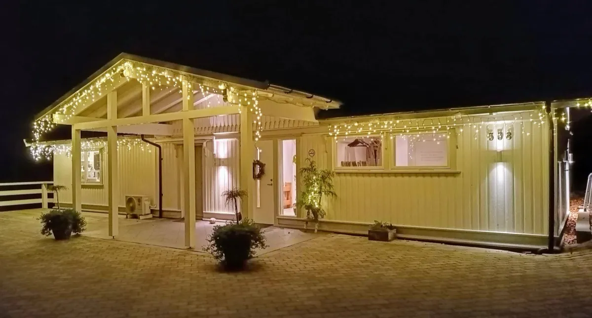 Verkstaden med julelys langs takskjegget en desemberkveld