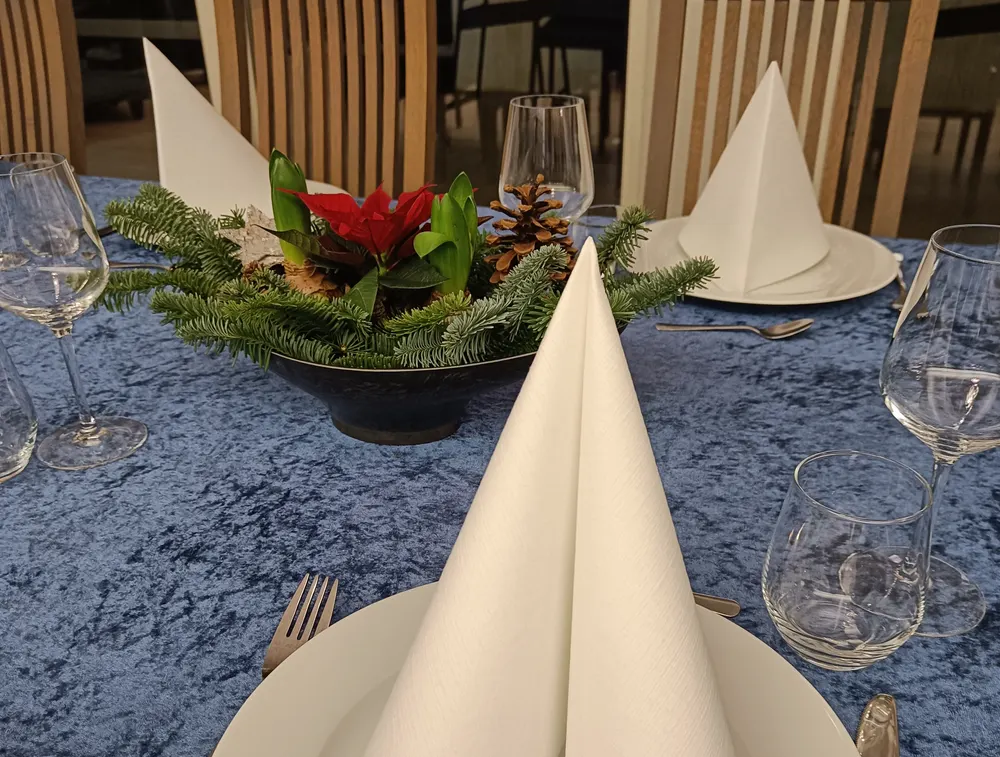 Kuvert med brettet serviett og julestjerne på blå duk